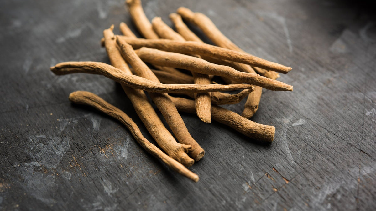 Dried ashwagandha root sticks on a dark wooden surface