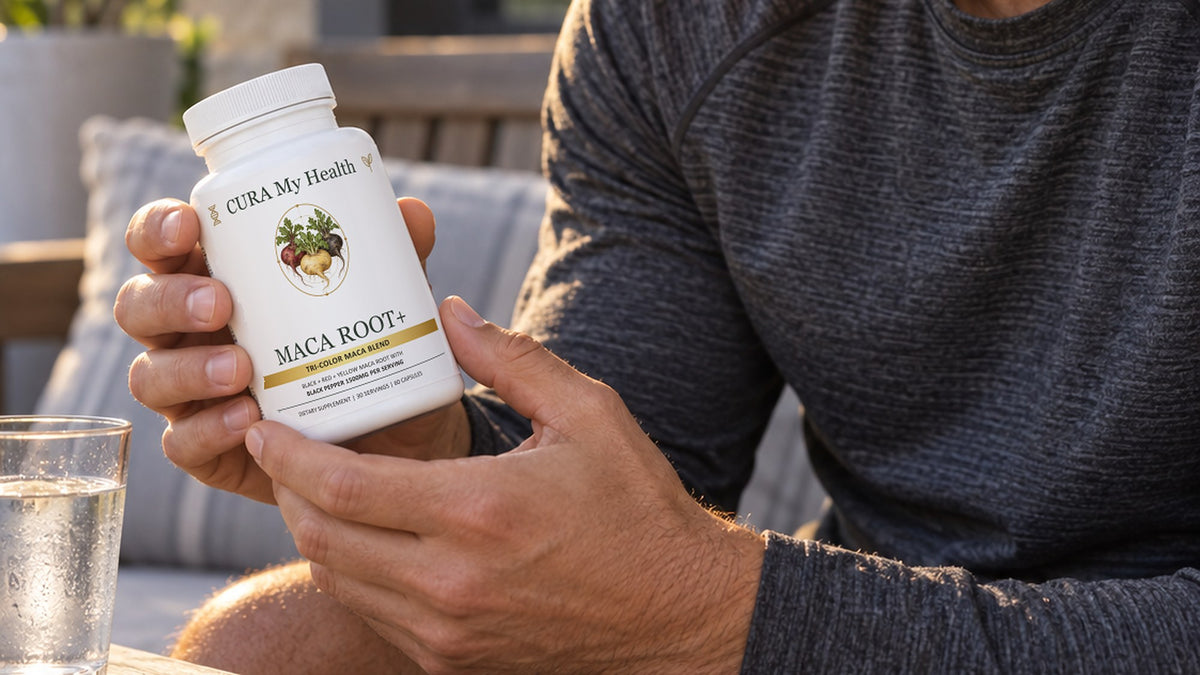 Two hands holding a Maca Root+ bottle on a patio beside a glass of water