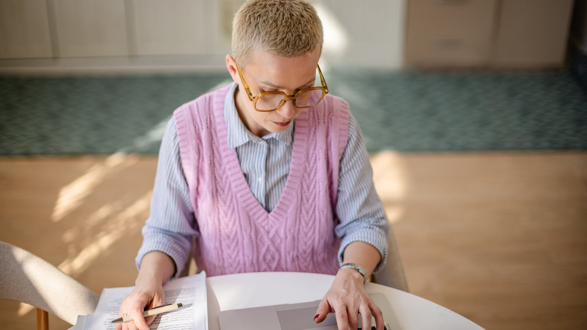 Focused woman in her 40s working at a bright home-office desk
