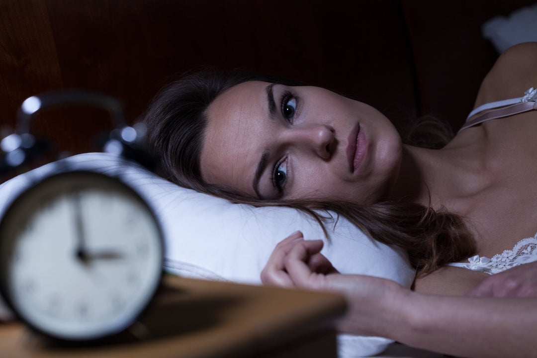 Woman awake at night comparing 5-HTP for women over 40 with melatonin