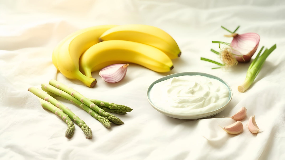 Bananas, oats, garlic, onions and asparagus beside yogurt, prebiotic and probiotic foods