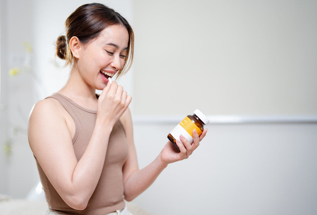 Woman taking a supplement capsule from a bottle as part of her evening wind-down routine