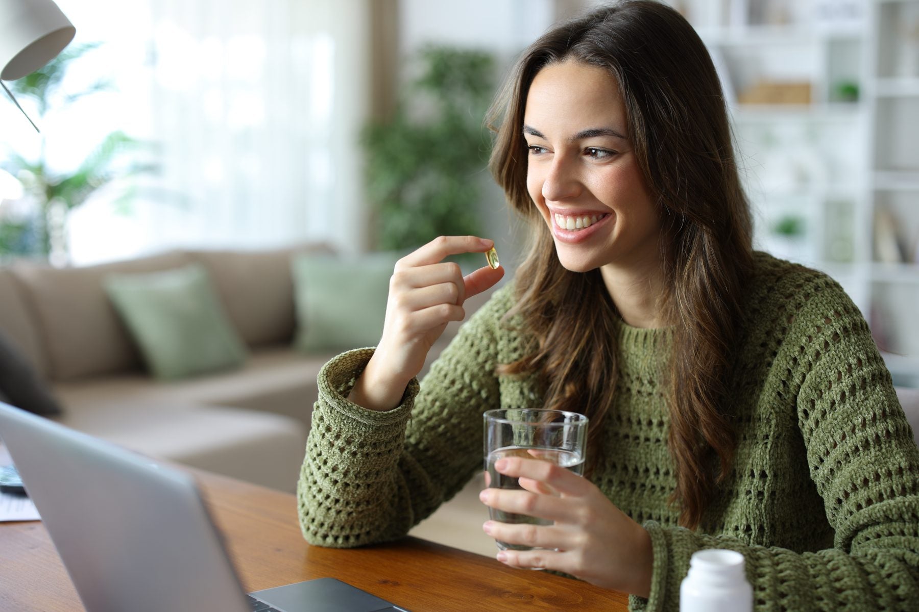 Woman taking her daily supplement as part of a simple AM/PM routine
