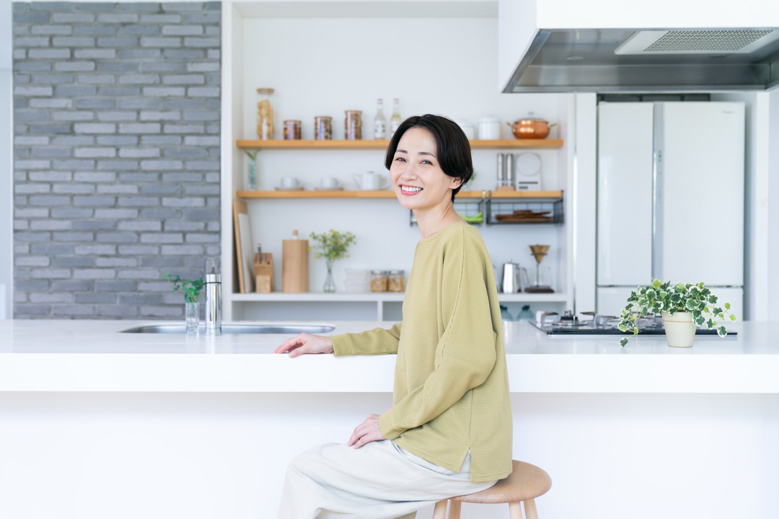 A woman with healthy, radiant skin in a bright, airy kitchen